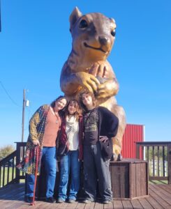 Julie and kids in front of Pearl the Squirrel at Berdoll Pecan Company near Bastrop, TX